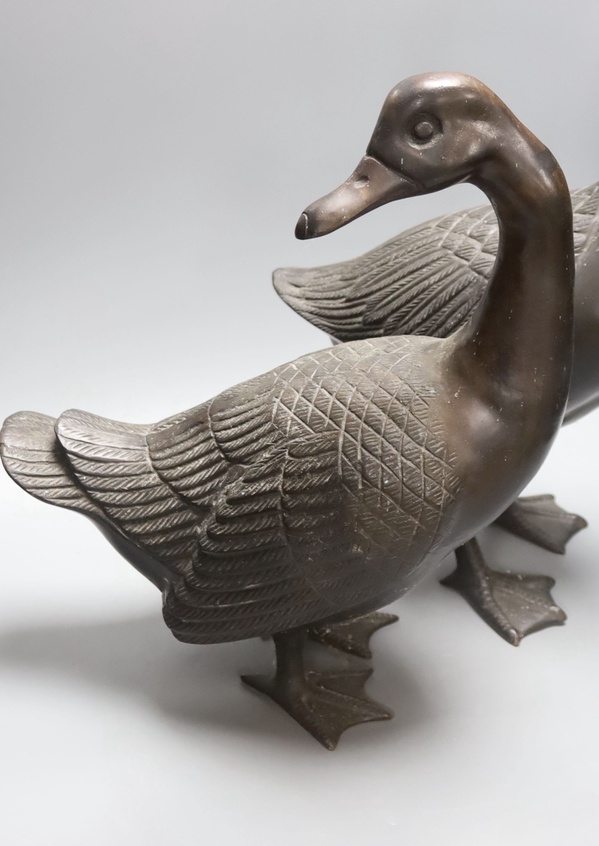 A pair of modern Chinese bronze models of geese, largest 48cm